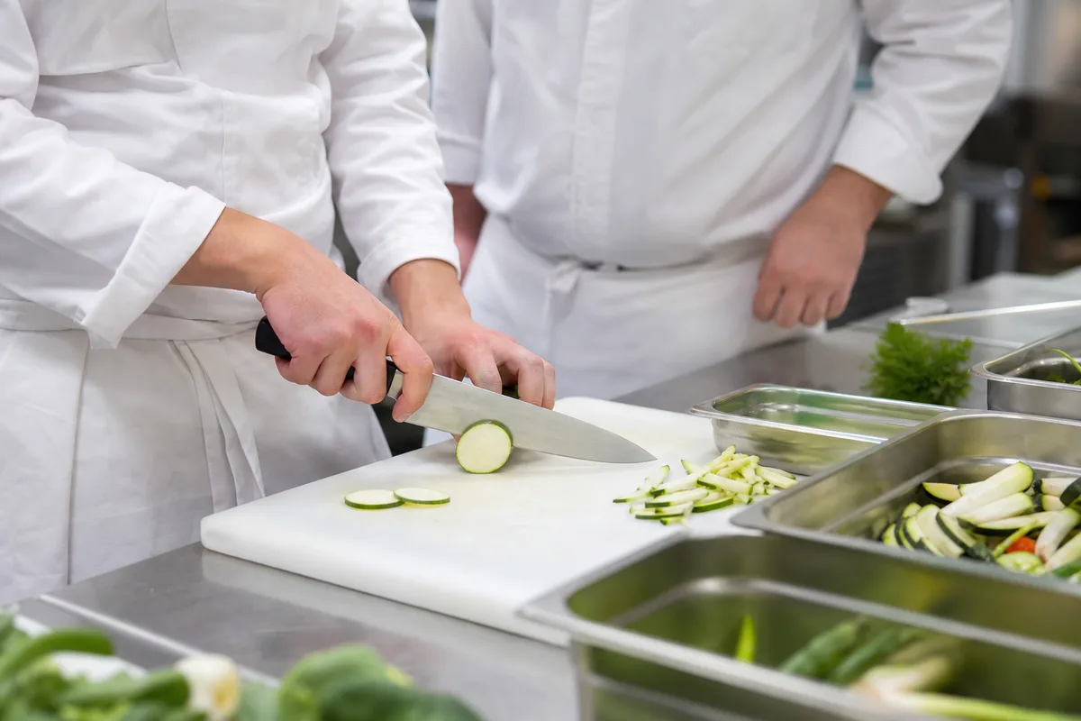 Apprenti apprenant la découpe dans une cuisine pédagogique de centre de formation